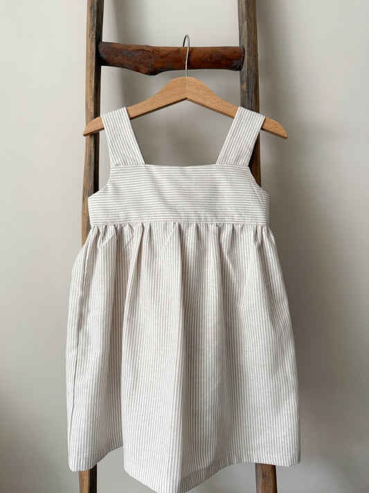 Rosie Dress sewing pattern featuring a classic children’s dress with wide shoulder straps, empire waist, gathered skirt, and open back bow tie. Includes pattern pieces, instructions, and finished garment views.