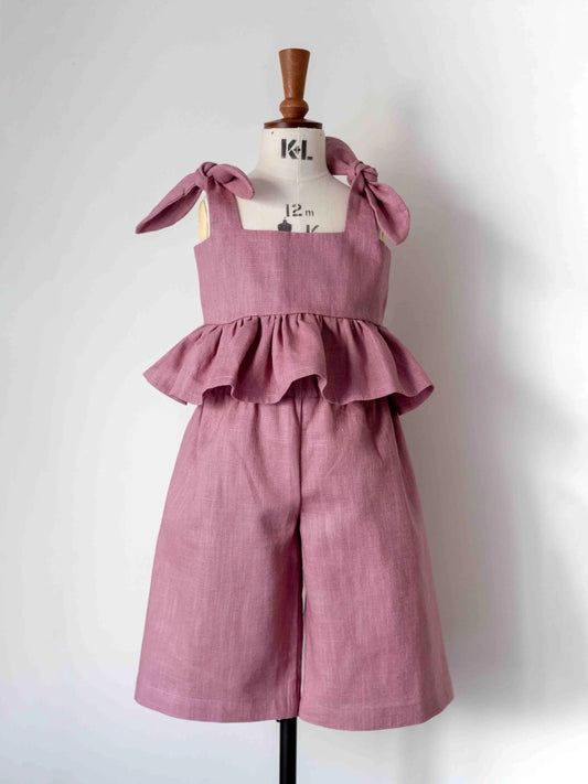 Pink ruffled dress on a mannequin against a white background