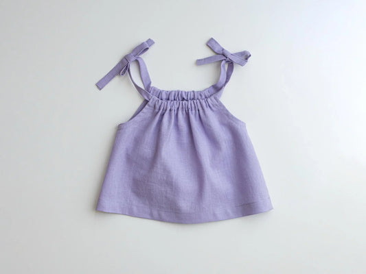 Purple dress with thin straps on a light gray background