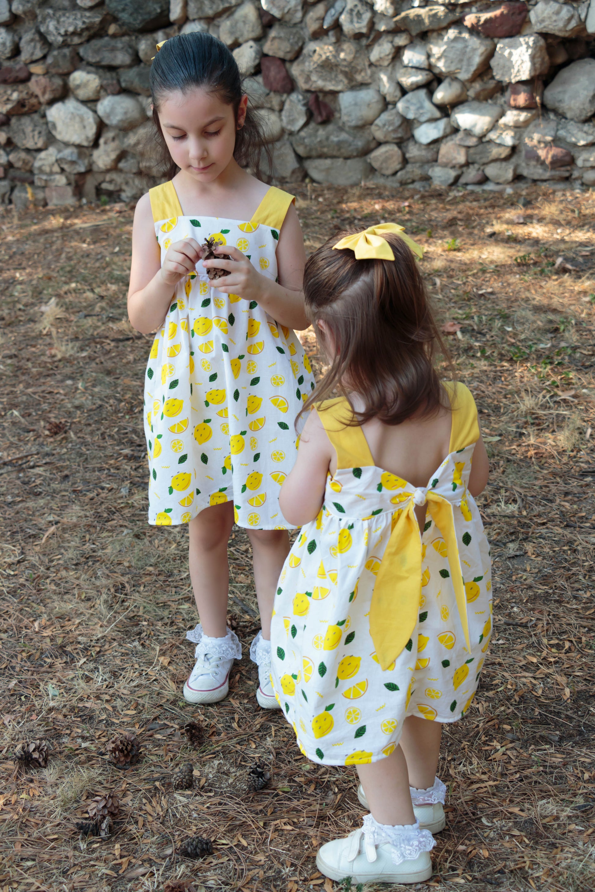 Easy beginner children’s sewing pattern for a classic dress with wide shoulder straps, empire waist, gathered skirt, and open back with bow tie detail.
