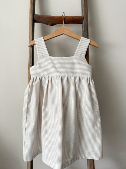 Rosie Dress sewing pattern featuring a classic children’s dress with wide shoulder straps, empire waist, gathered skirt, and open back bow tie. Includes pattern pieces, instructions, and finished garment views.