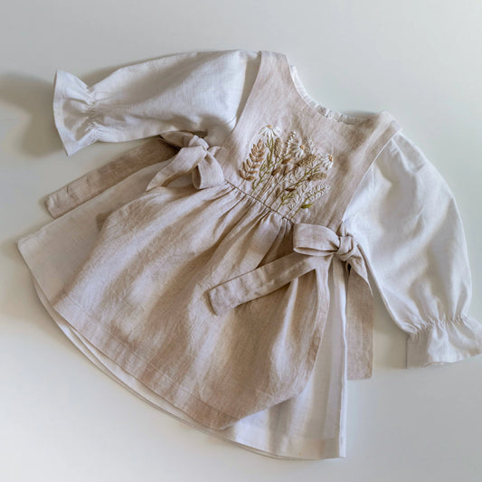 Beige dress with floral embroidery on a white background