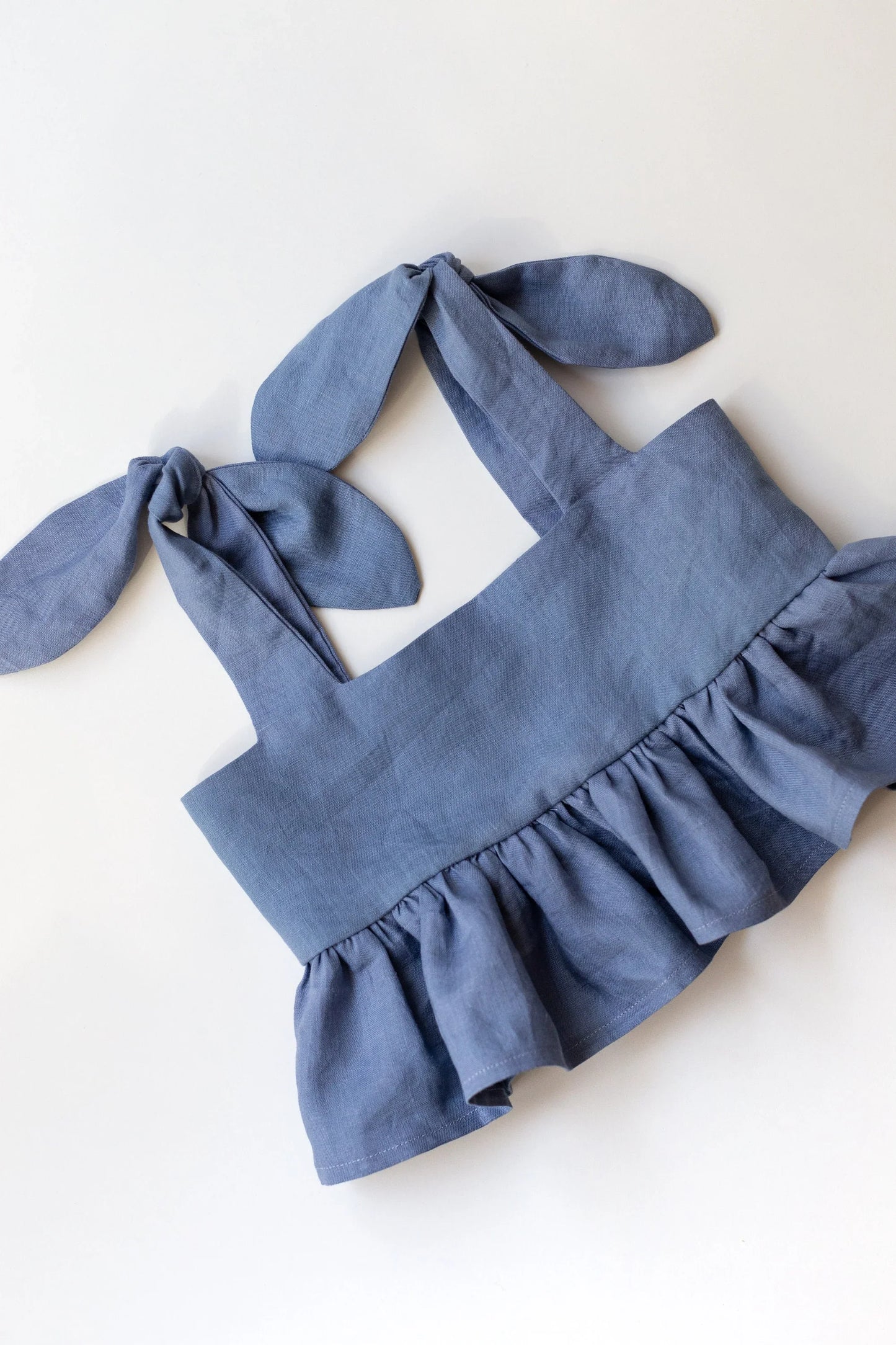 Blue children's top with bunny ears on a white background