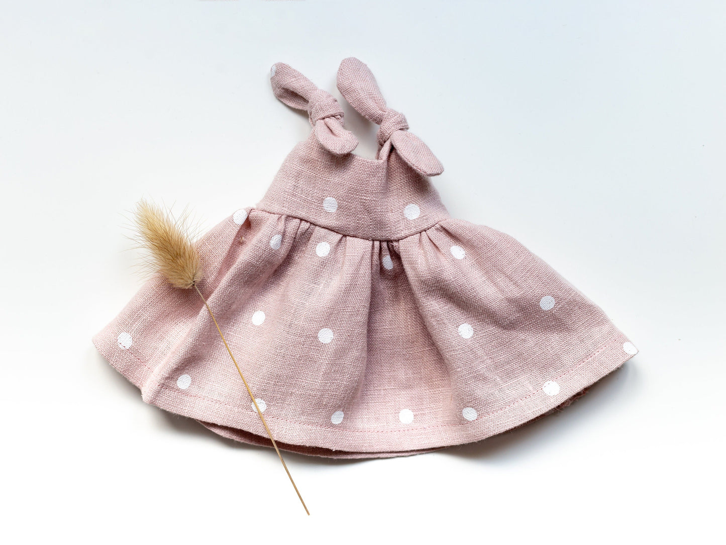 Pink polka dot dress with bow on a white background