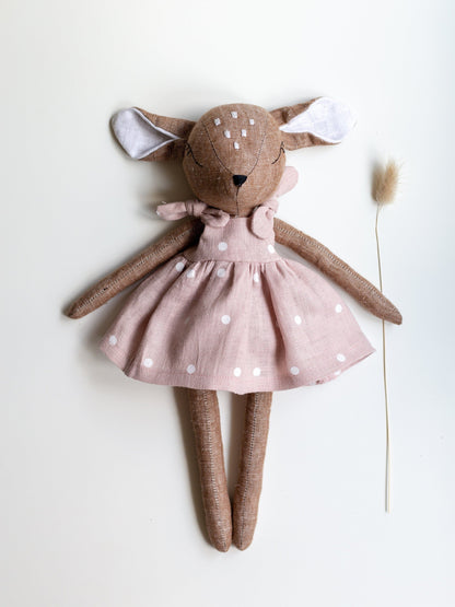 Stuffed animal toy with a pink dress on a white background