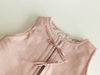 Pink dress with floral shoulder details on a light green background