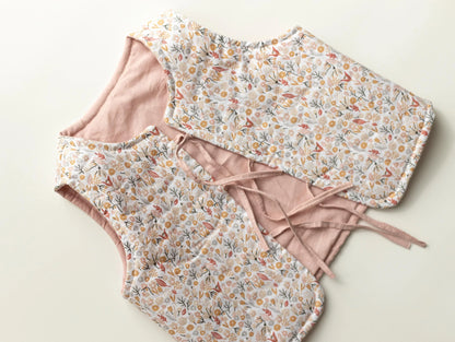 Baby romper with floral and solid pink design on a light background
