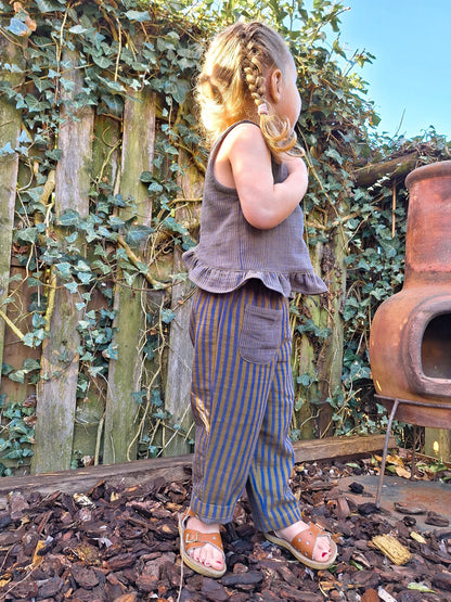 Child standing outdoors with a rustic background