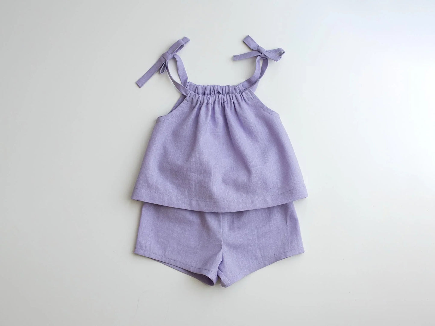 Lavender children's top and shorts set on a light gray background