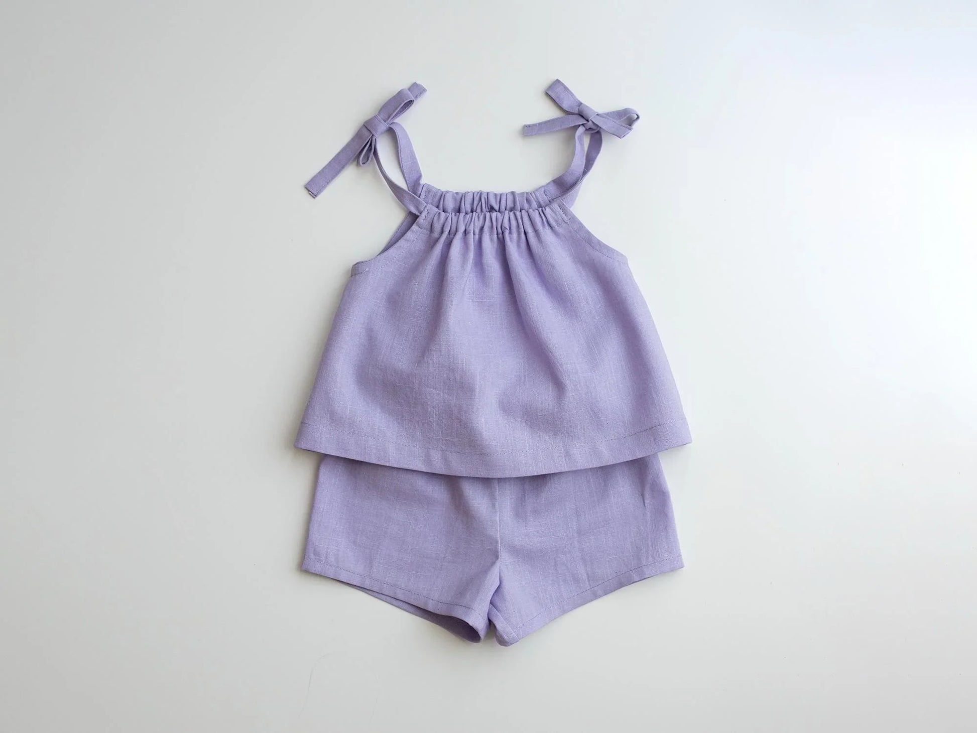 Lavender children's top and shorts set on a light gray background