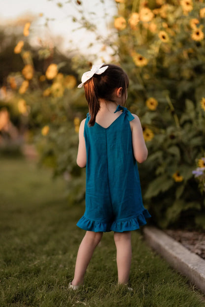 Young girl in a blue dress standing in a sunflower field